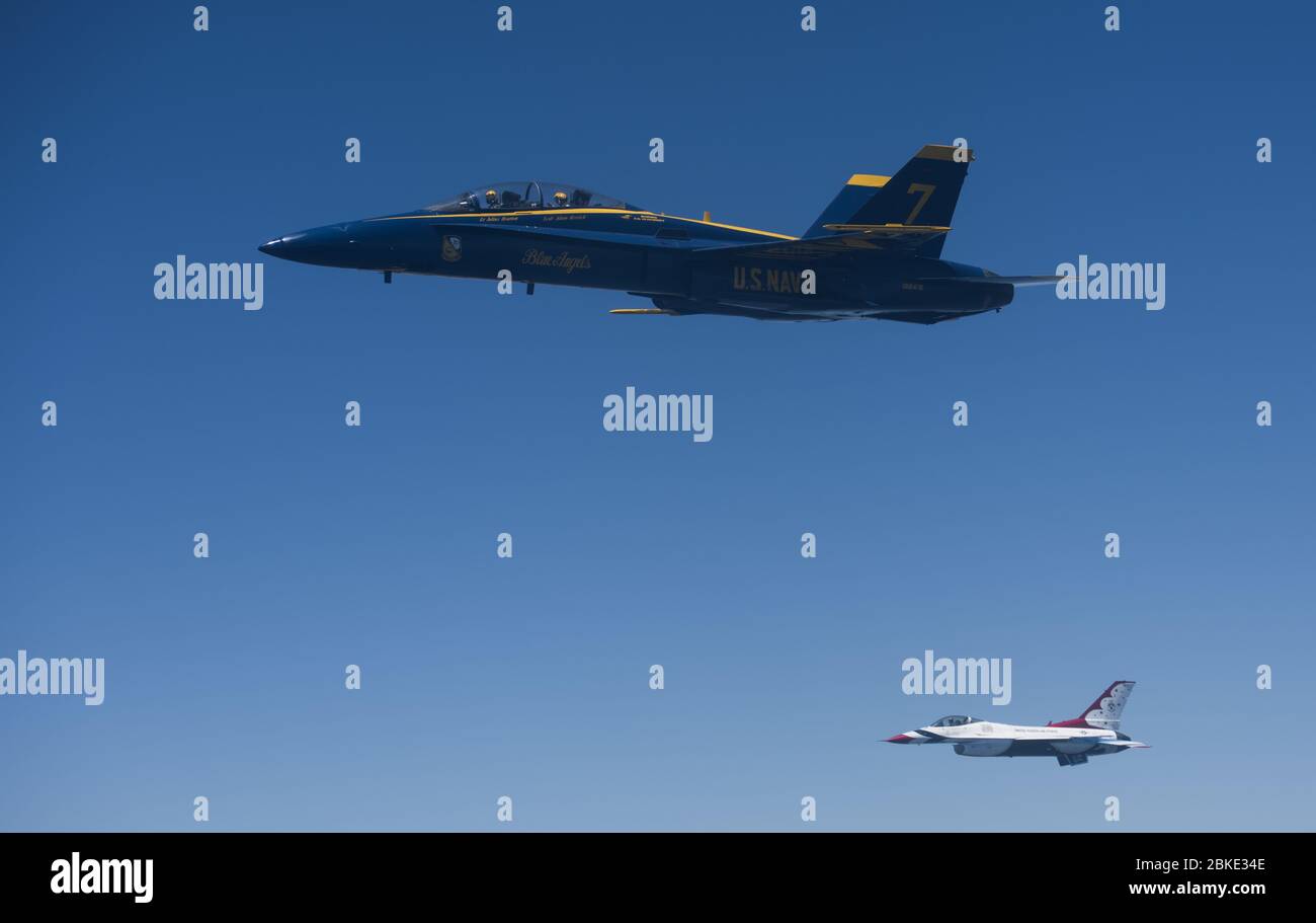 An F/A-18 Hornet assigned to the U.S. Navy Blue Angels and an F-16 Fighting Falcon assigned to the U.S. Navy Thunderbirds during a flyover as part of the America Strong campaign over Atlanta, Washington DC and Baltimore, May 2, 2020. The demonstration teams flew for the campaign to honor healthcare workers, first responders, and other essential peronnel who are working on the front lines to combat COVID-19. (U.S. Air Force photo by Senior Airman Ariel Owings) Stock Photo