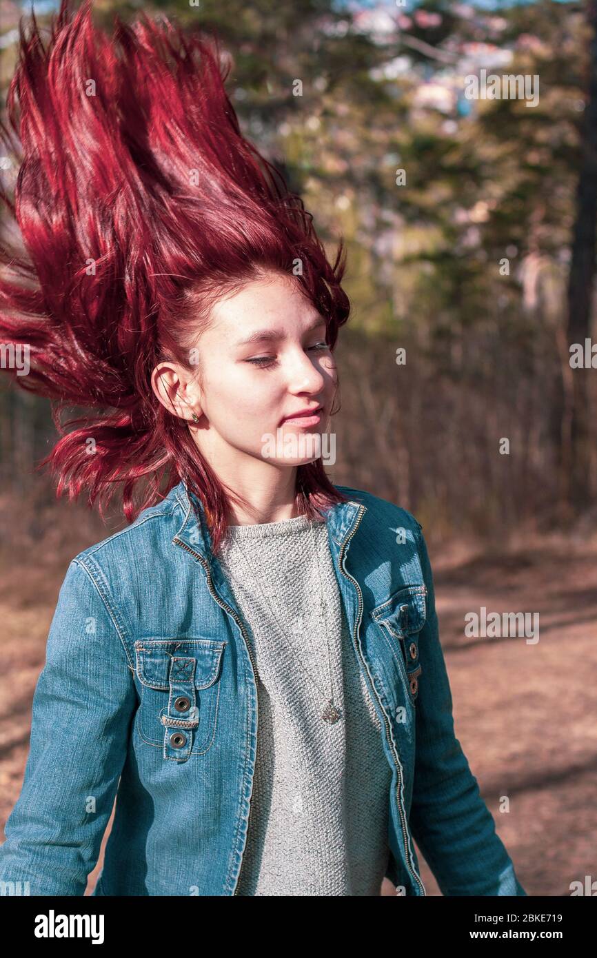 A young girl throws her head back and red hair froze upstairs. Hair