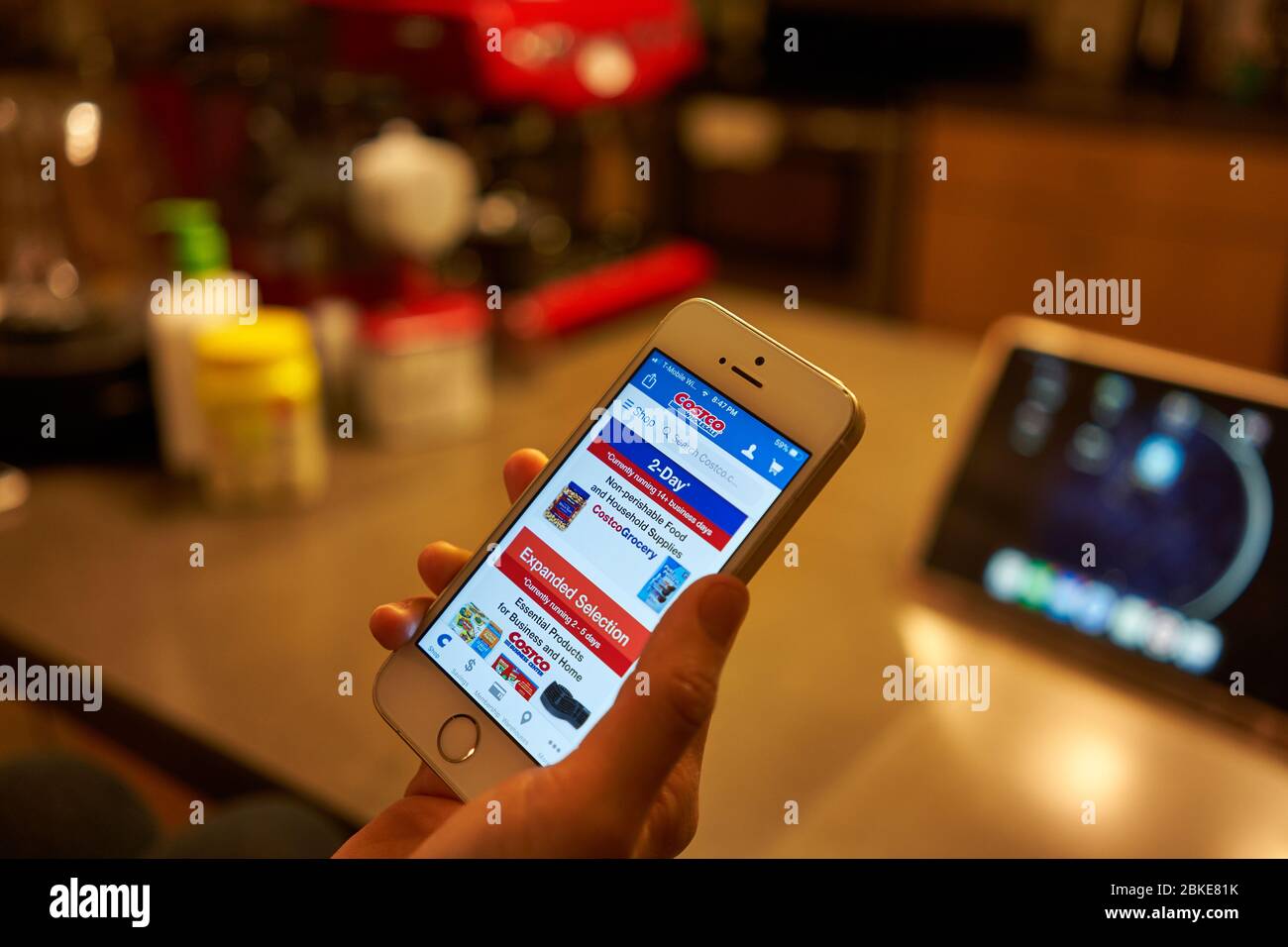 Portland, OR, USA - May 1, 2020: A woman uses the Costco mobile app to order groceries online. Stock Photo