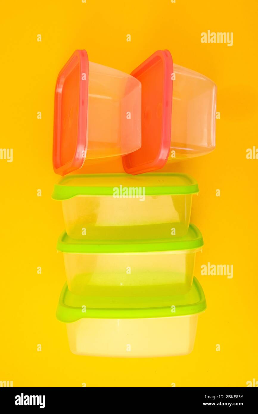 Plastic lunch boxes on yellow background, Colorful Plastic Containers