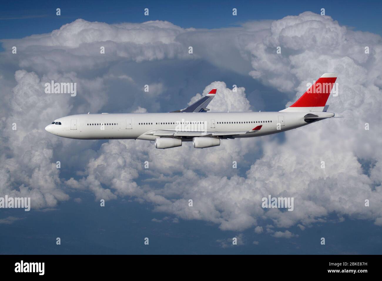 Air travel. Long haul passenger jet plane flying in the air at high altitude against a cloudy sky on a commercial flight. Airplanes and flights. Stock Photo