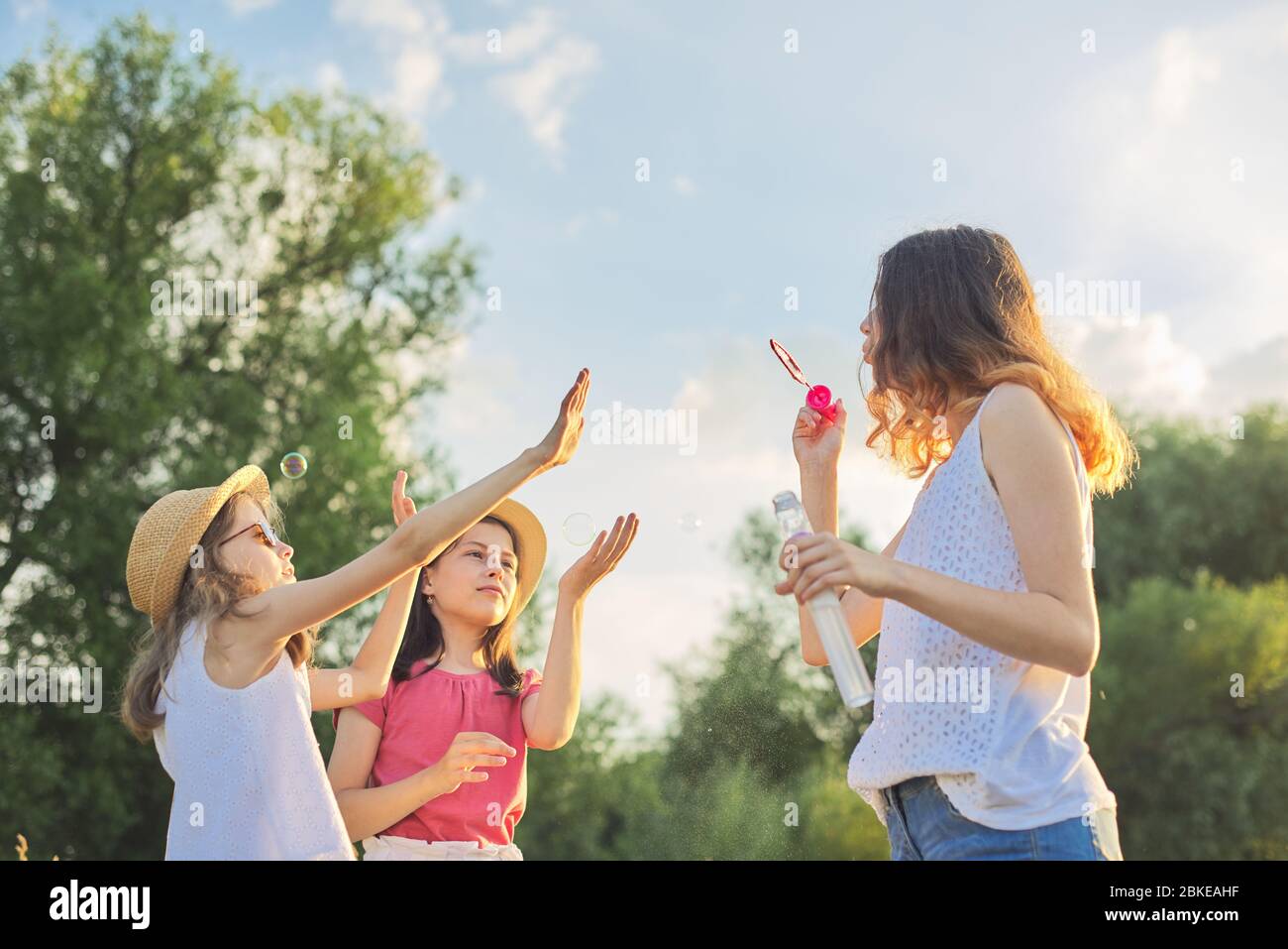 Children three girls playing with soap bubbles Stock Photo - Alamy