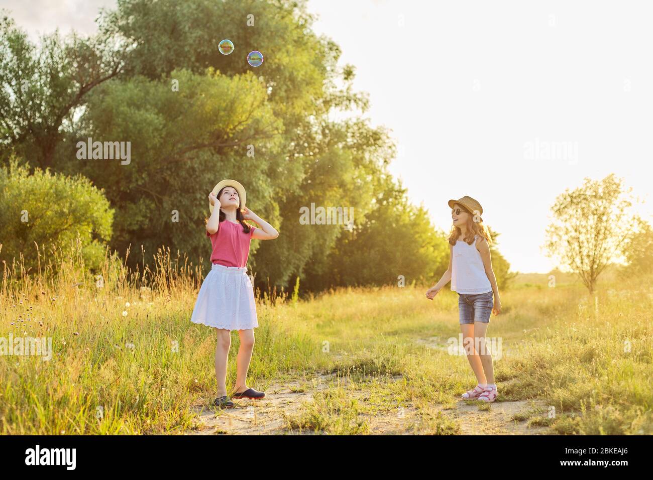 Children two girls playing with soap bubbles Stock Photo - Alamy