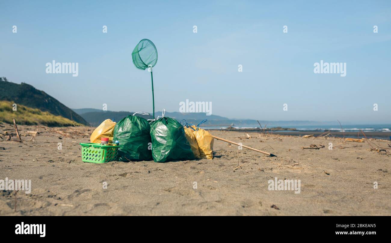 Garbage bags and utensils on the beach Stock Photo