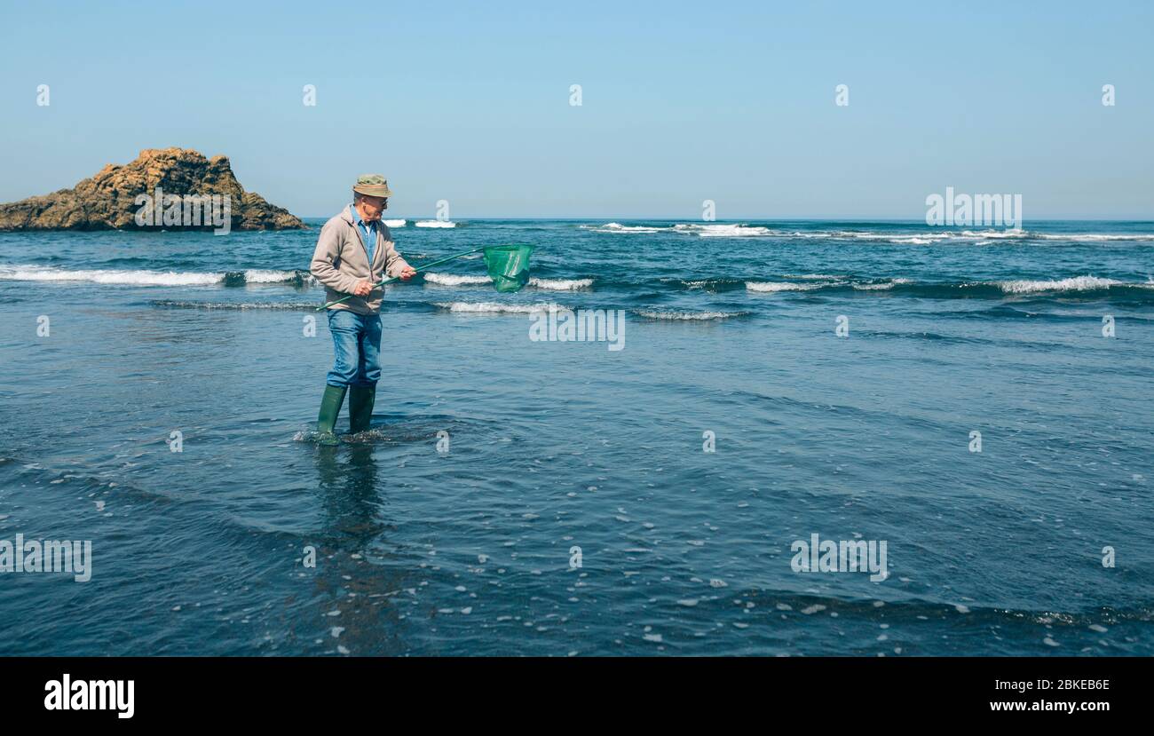 Volunteer taking garbage out of the sea Stock Photo
