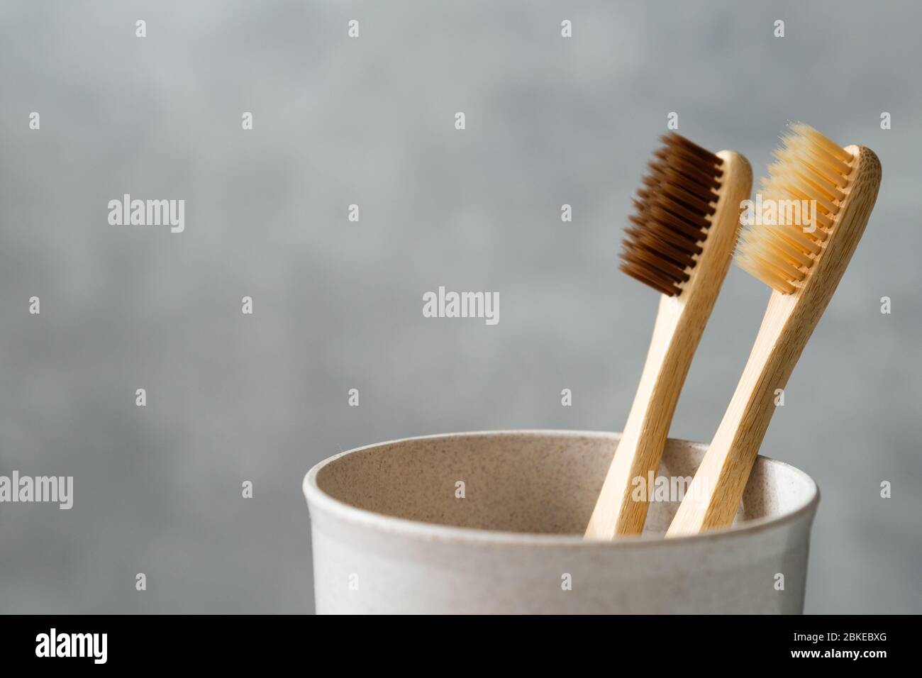 Eco friendly bamboo toothbrushes in glass, close-up view. Two ...