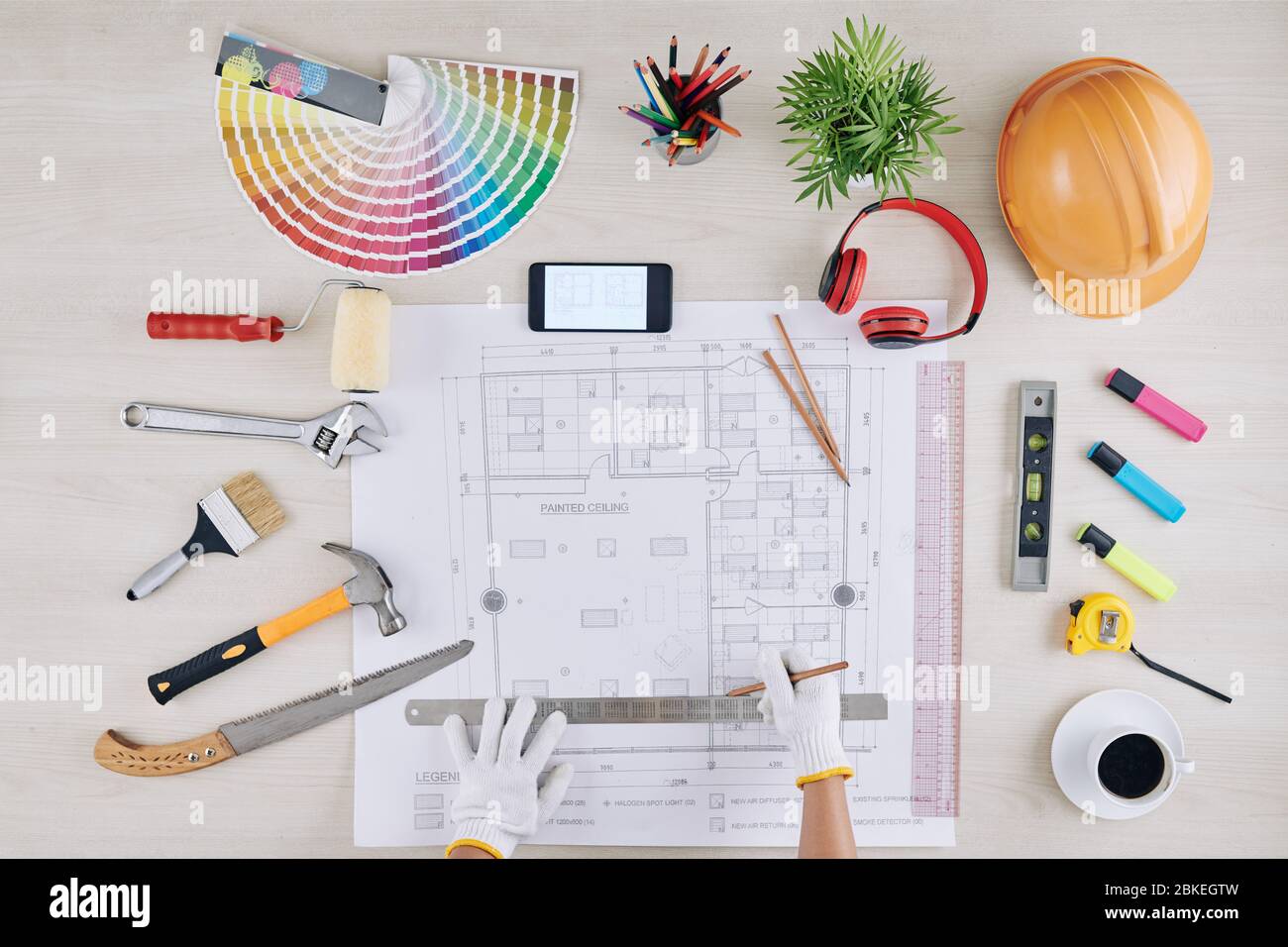 Construction worker measuring house blueprint with metal ruler at his ...
