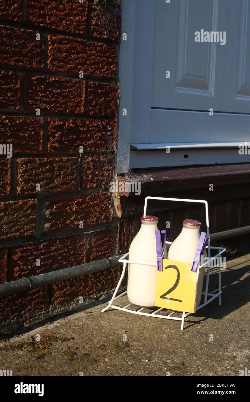 Milk crate on driveway by front door of a house with doorstep milk