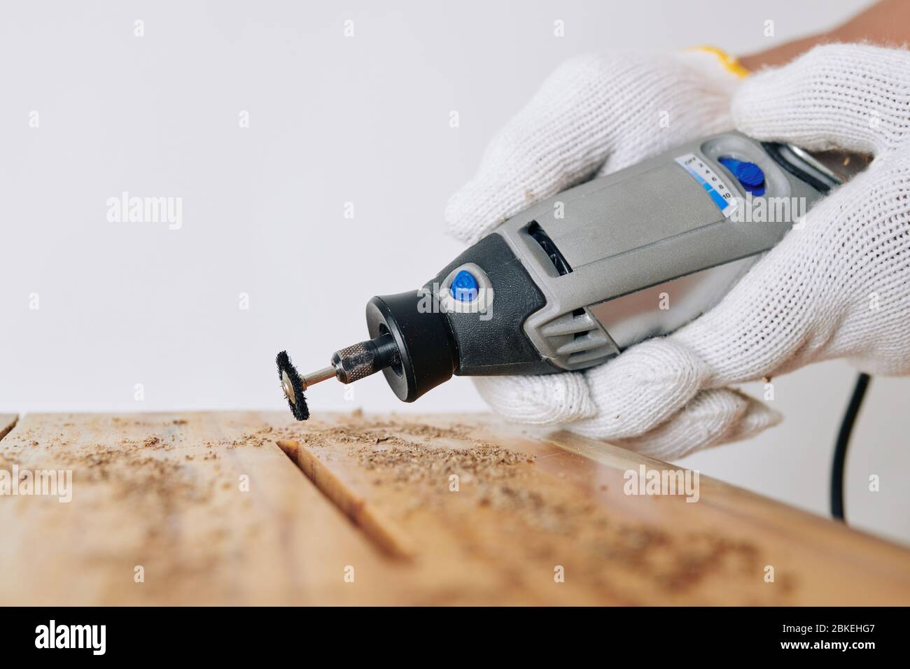 Professional carpenter using rotary hand tool to clean elongated hole