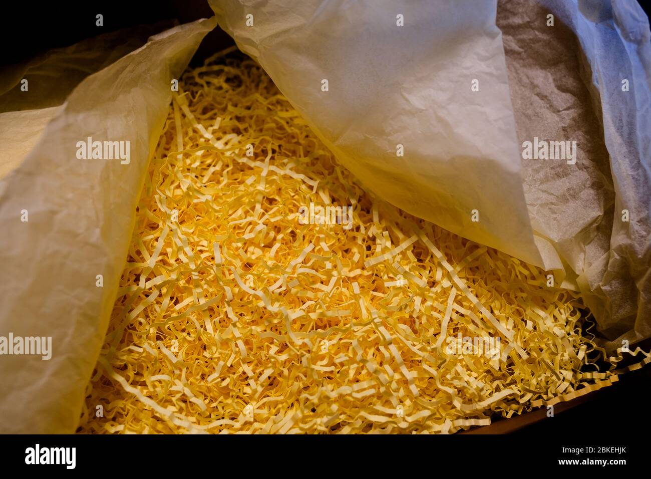 Opened recycled taped cardboard posting and shipping box with shredded Paper Packing Material Delivery, mail service,shipment concept Stock Photo