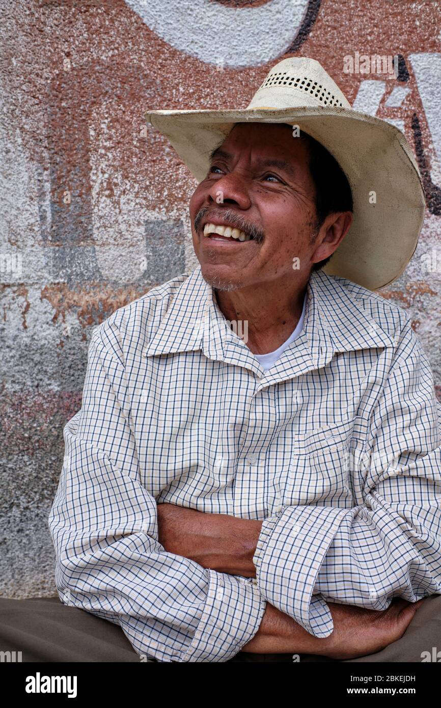 Portrait of middle-aged man with cowboy hat sitting at the door of his house in Amatenango del Valle. Stock Photo