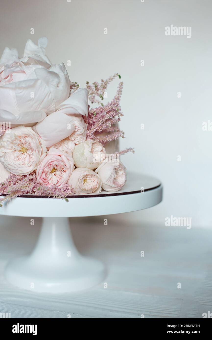 Decorated with fresh flowers, white naked cake, a stylish cake for weddings, birthdays and events. Stock Photo