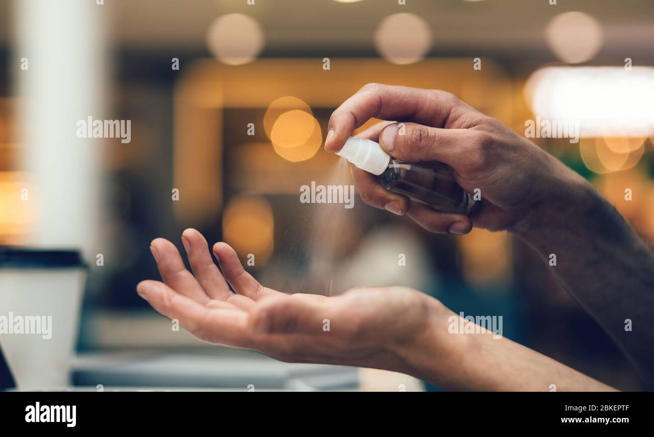 close up. man uses an antiseptic hand spray Stock Photo Alamy