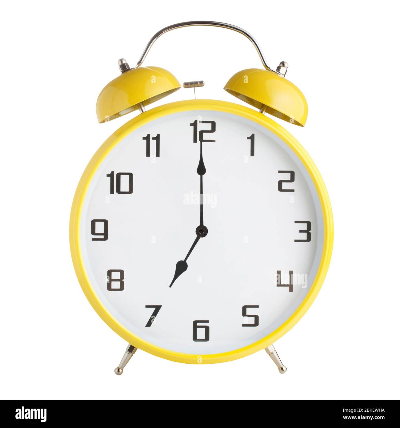 Yellow analog alarm clock showing seven o'clock isolated on white