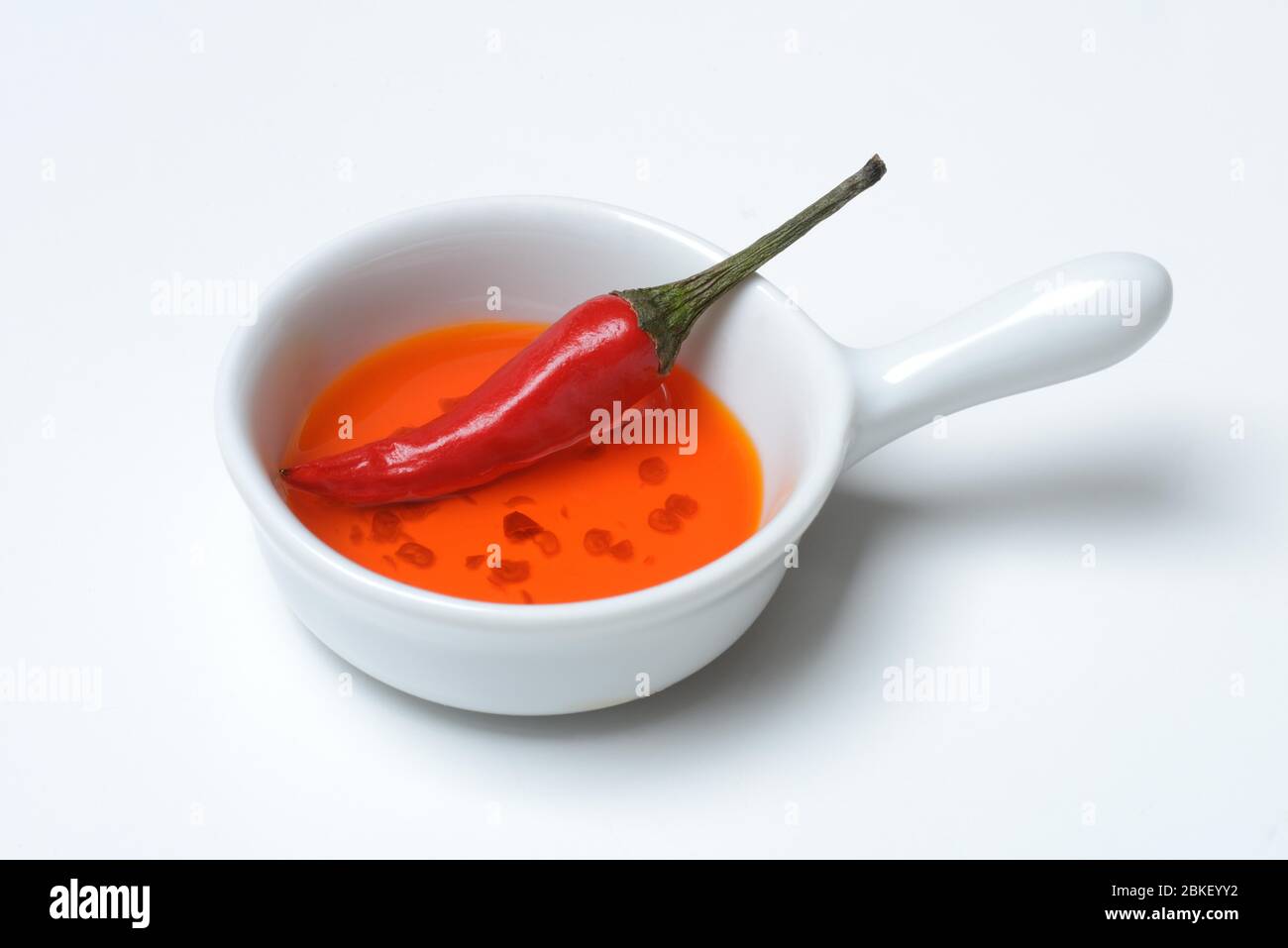 Chili oil and chili pepper in ceramic vessel, food photography, studio shot, Germany Stock Photo