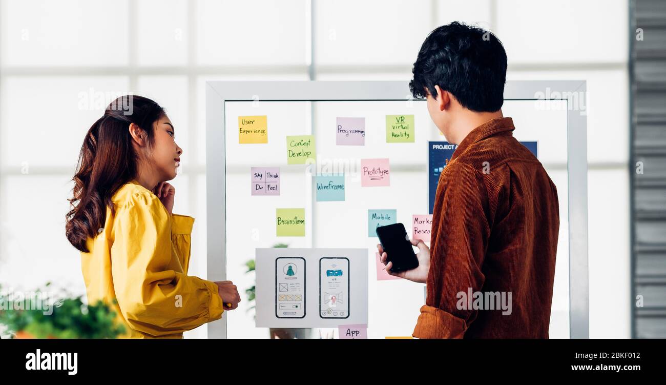 ux developer and ui designer presenting  and testing mobile app interface design on whiteboard in meeting at modern office.Creative digital developmen Stock Photo