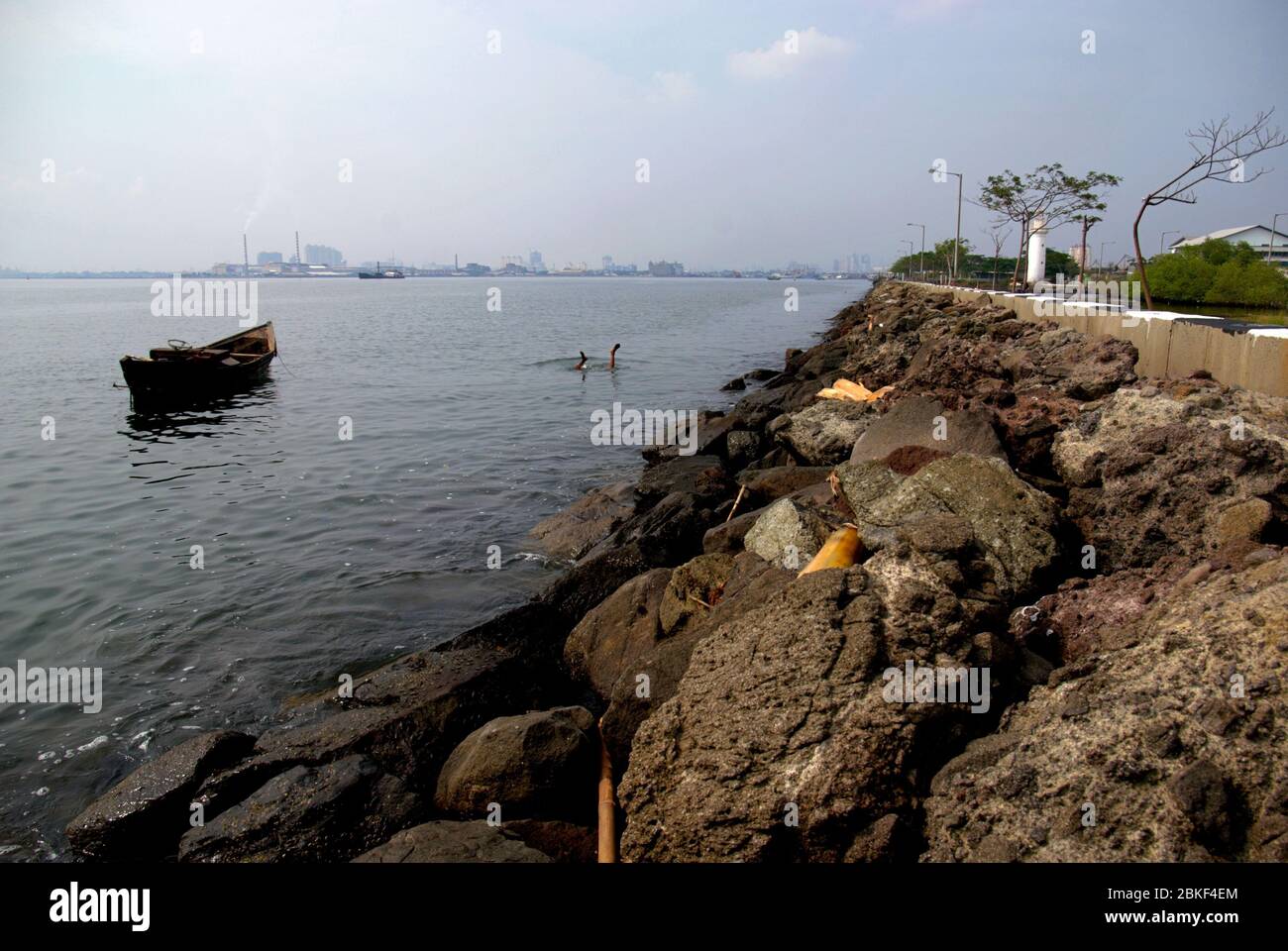 Man duckdiving to search usable items on the coastal waters of Jakarta in Muara Baru area. Archival photo. North Jakarta, Special Capital Region of Jakarta, Indonesia. Photo: Reynold Sumayku Stock Photo