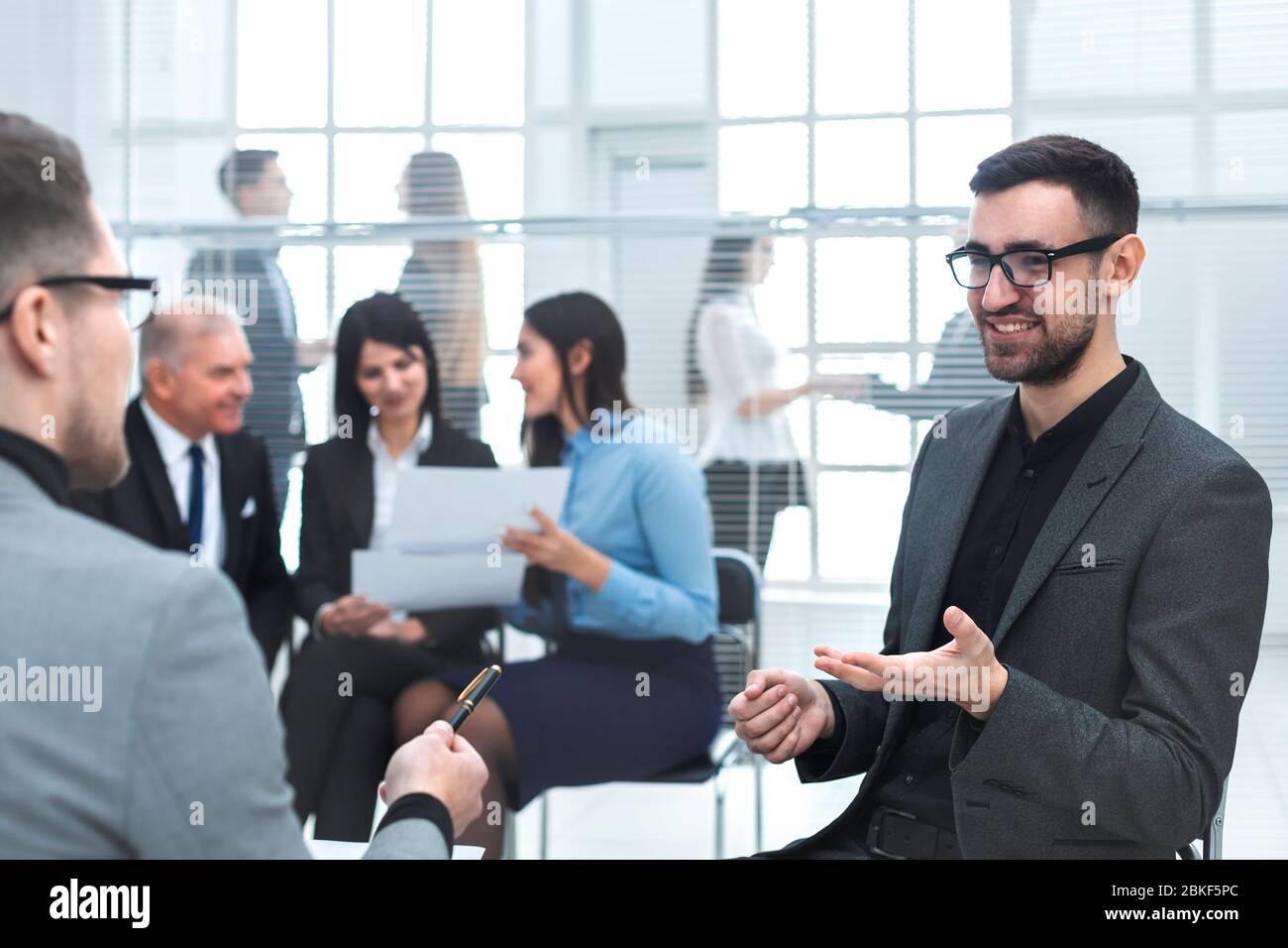 business man discussing something sitting near the office Desk Stock Photo
