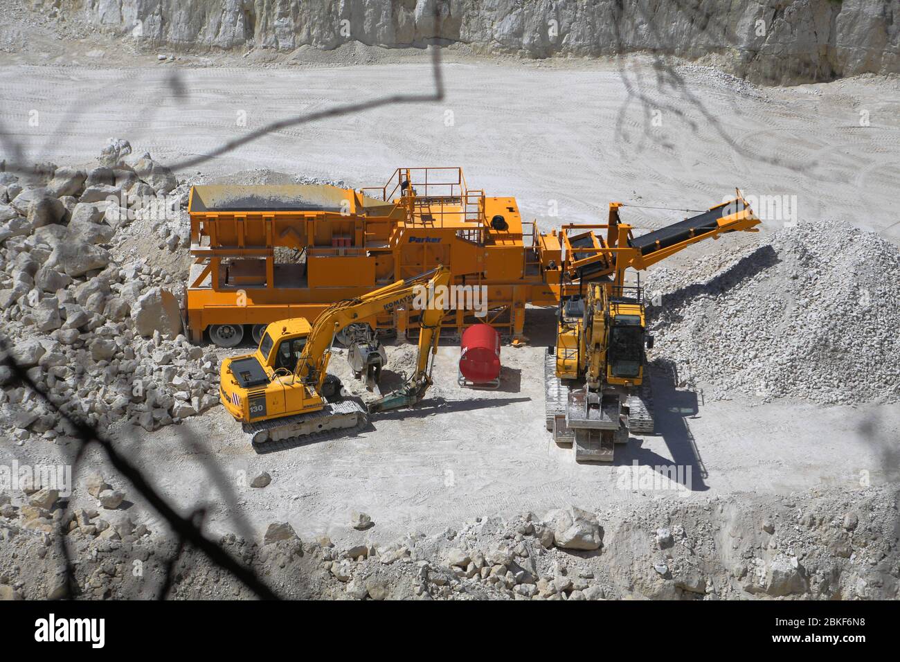 Overlooking a bright chalk quarry to the heavy machines that look like toys Stock Photo
