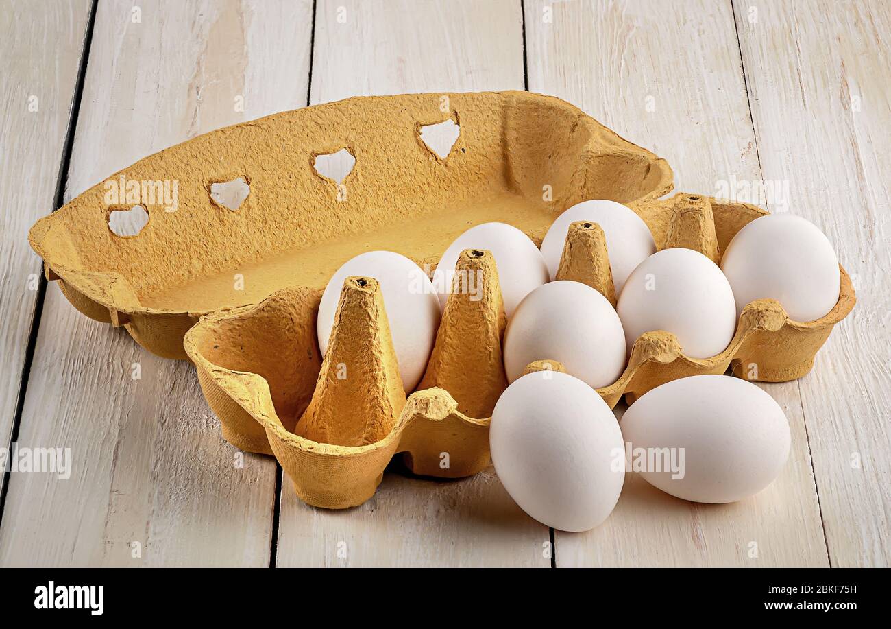 Eggs near the tray on white table Stock Photo