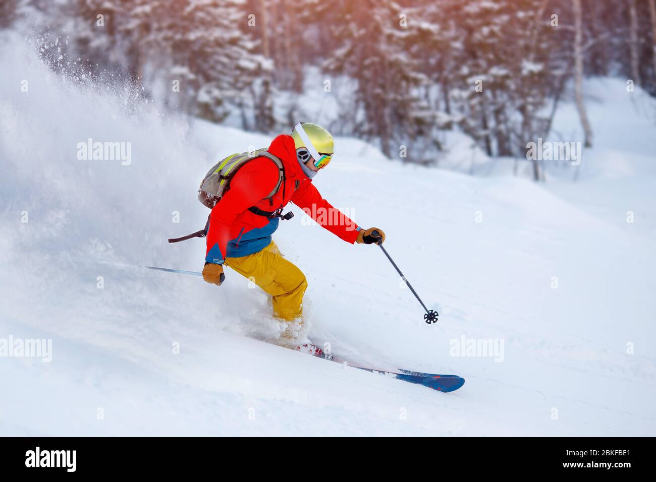Man athlete mountain skiing rides on soft snow track in woods, chest