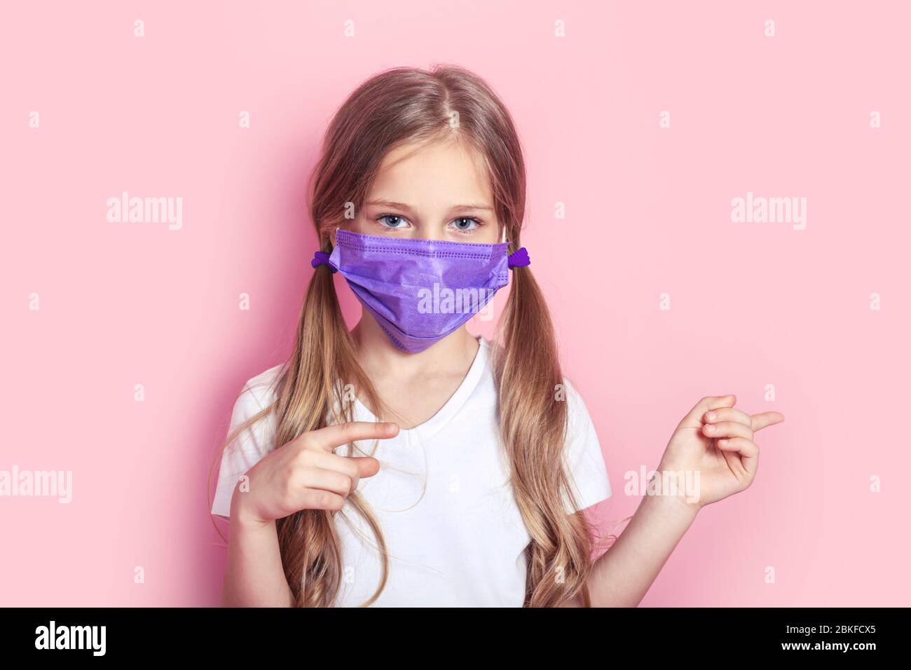 Portrait of kid with protective face mask show away on color background ...