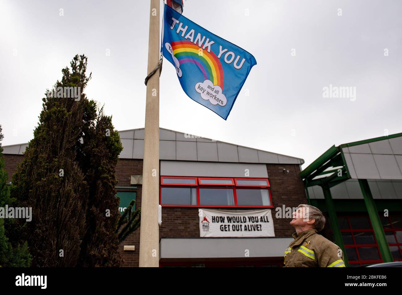 Flags are flown at half mast as firefighters observe a minute's silence outside Bournbrook Community fire station in Birmingham, in memory of their colleagues that lost their lives in the line of duty. Stock Photo