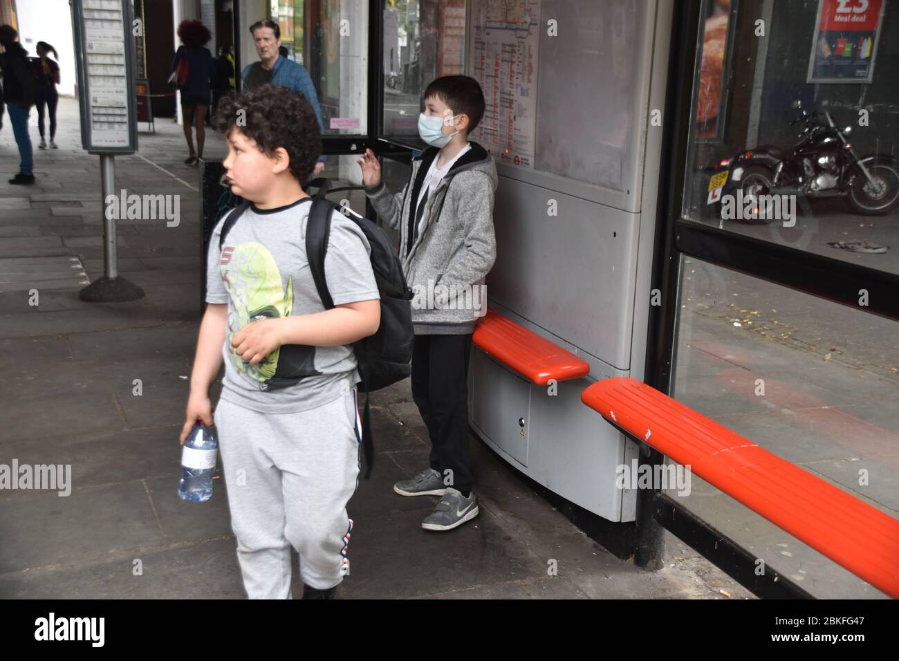 Boys waiting at Bus stop during Lockdown Stock Photo