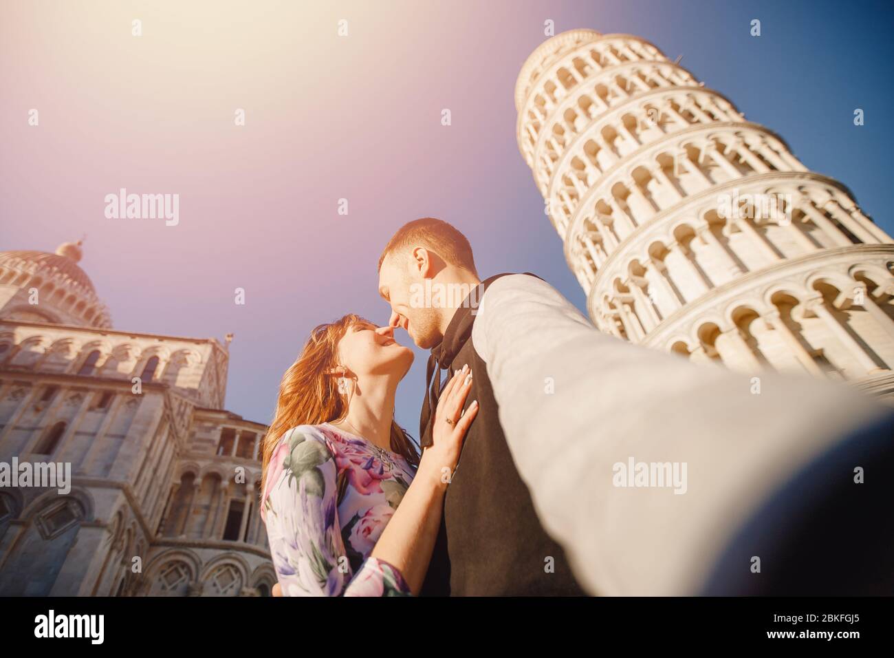 Travel concept. Loving happy couple takes selfie photo on stick and camera  against background of leaning Tower Pisa, Italy Stock Photo - Alamy