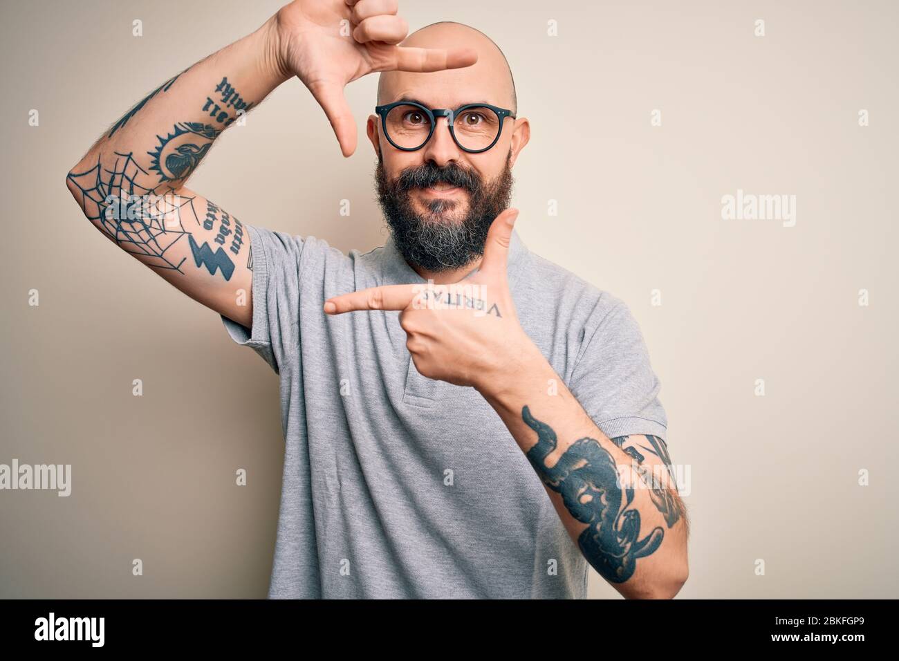 Handsome bald man with beard and tattoo wearing casual polo and glasses  smiling making frame with hands and fingers with happy face. Creativity and  ph Stock Photo - Alamy