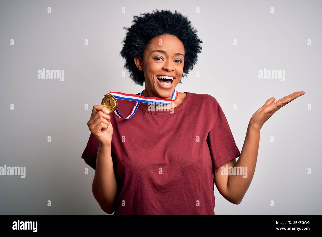 Young African American athlete woman with curly hair wearing gold medal