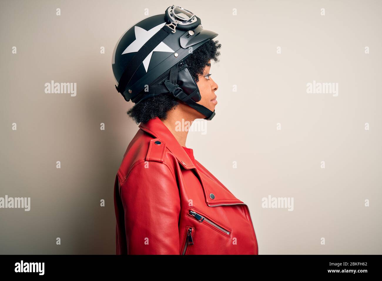 Young African American afro motorcyclist woman with curly hair wearing  motorcycle helmet looking to side, relax profile pose with natural face  with co Stock Photo - Alamy