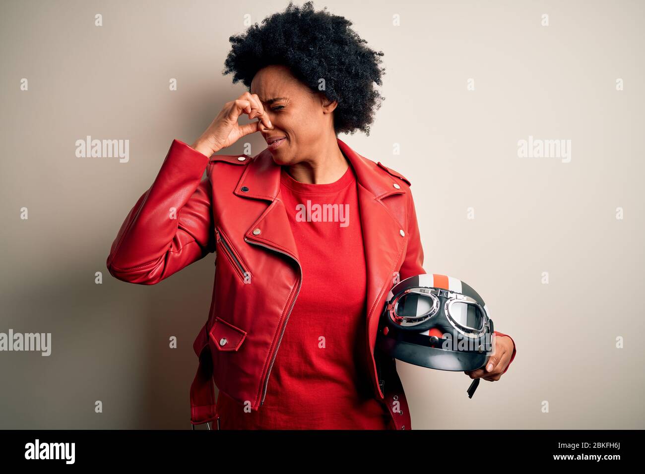 Young African American afro motorcyclist woman with curly hair holding