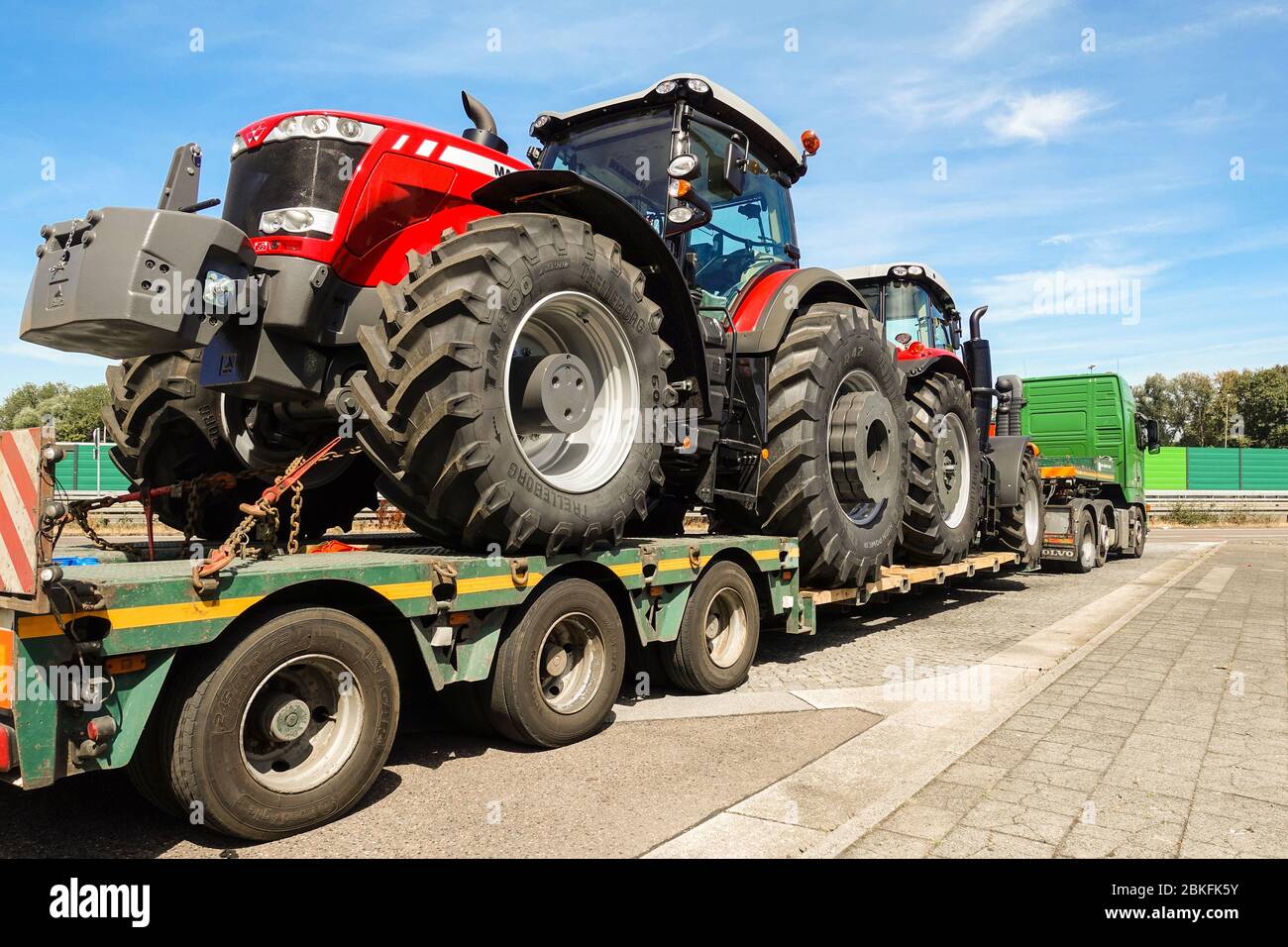 AACHEN, NRW, GERMANY - JULY 27, 2018: Heavy haulage of big tractors on a special low-loader trailer truck, parking road sight on a highway Stock Photo