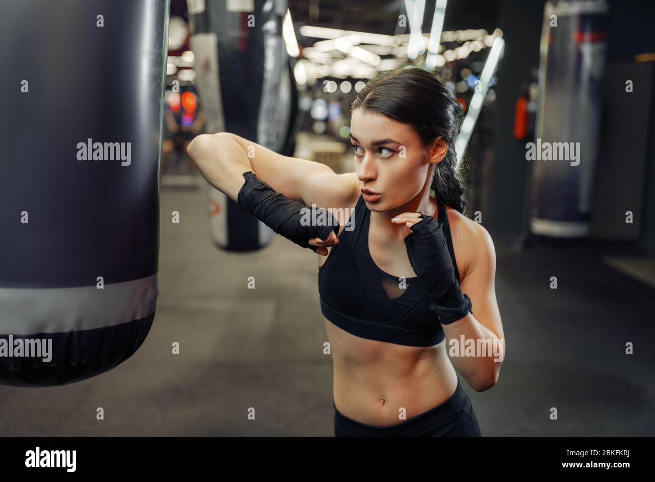 Woman hits a punching bag, thai boxing training Stock Photo