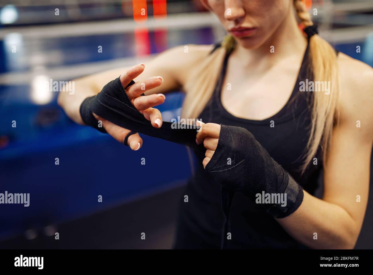 Woman winds up black bandages, boxing training Stock Photo