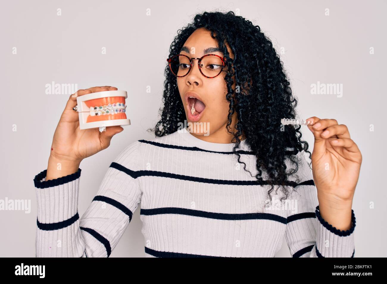 Young beautiful african american woman with curly hair wearing glasses ...