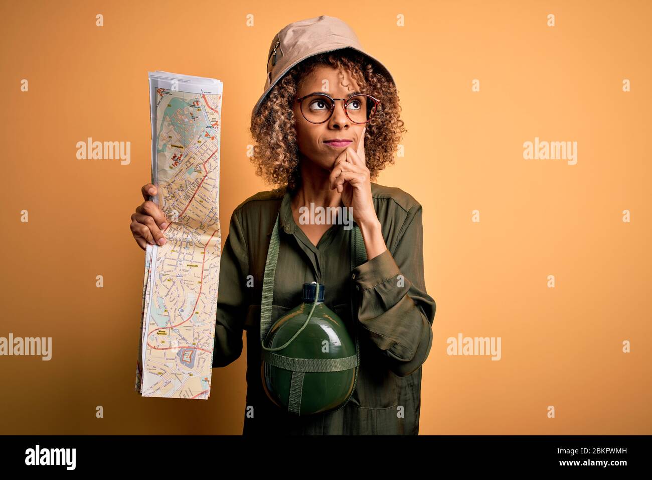 African american tourist woman wearing explorer hat and water canteen ...