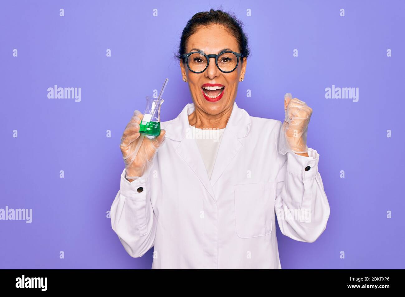 Middle age senior scientist woman wearing laboratory coat holding ...