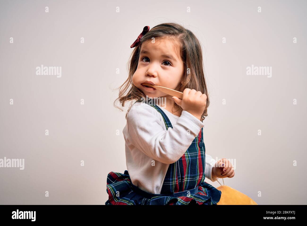 Young little infant girl brushing her teeth using tooth brush and oral paste, cleaning teeth and tongue as healthy health care morning routine. Learni Stock Photo