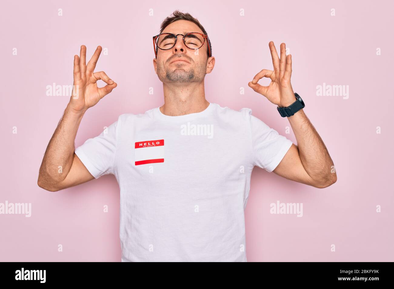Handsome man with blue eyes wearing sticker with hello my name is ...