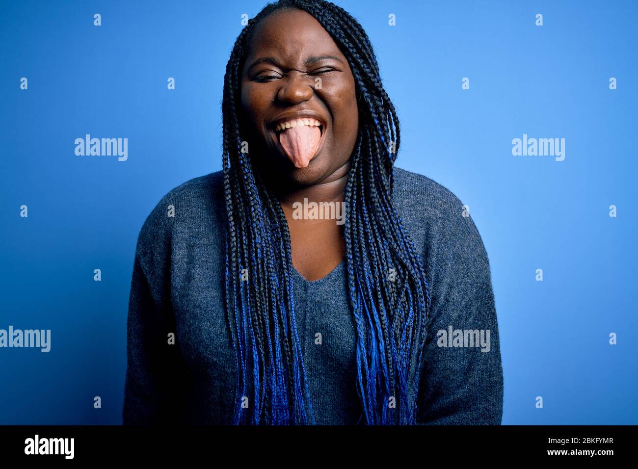 African american plus size woman with braids wearing casual sweater ...