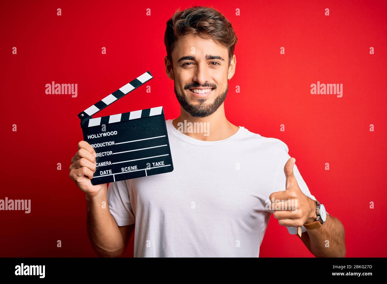 Young director man with beard making movie using clapboard over ...