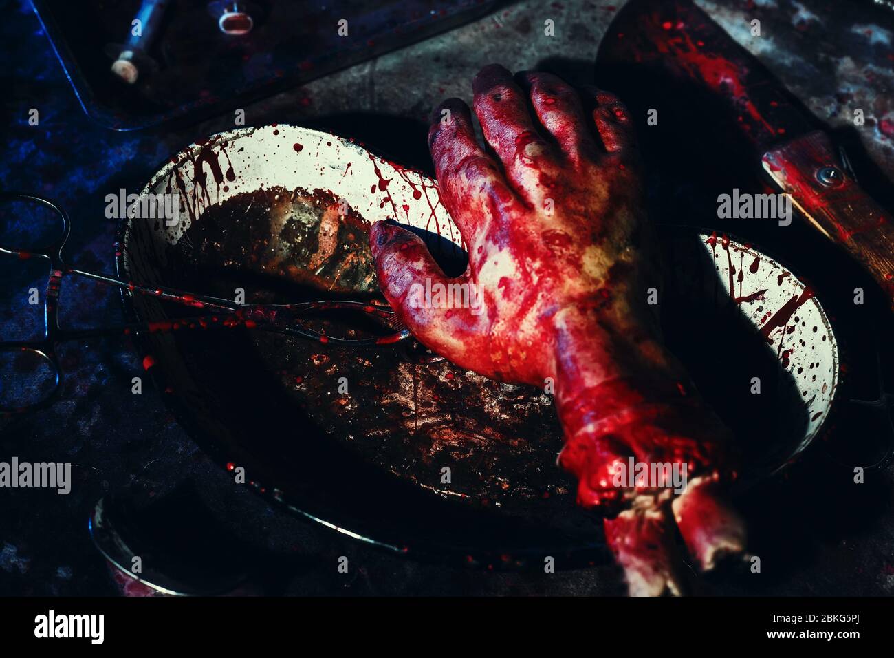 A place of torture crazy maniac. Bloody medical tools and the severed limb hand. Dark and terrible background. Stock Photo