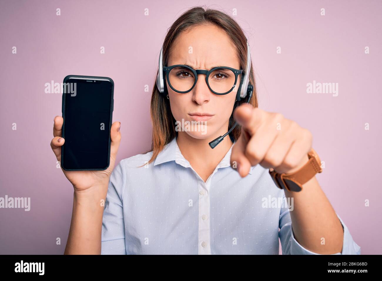 Beautiful call center agent woman working using headset holding ...