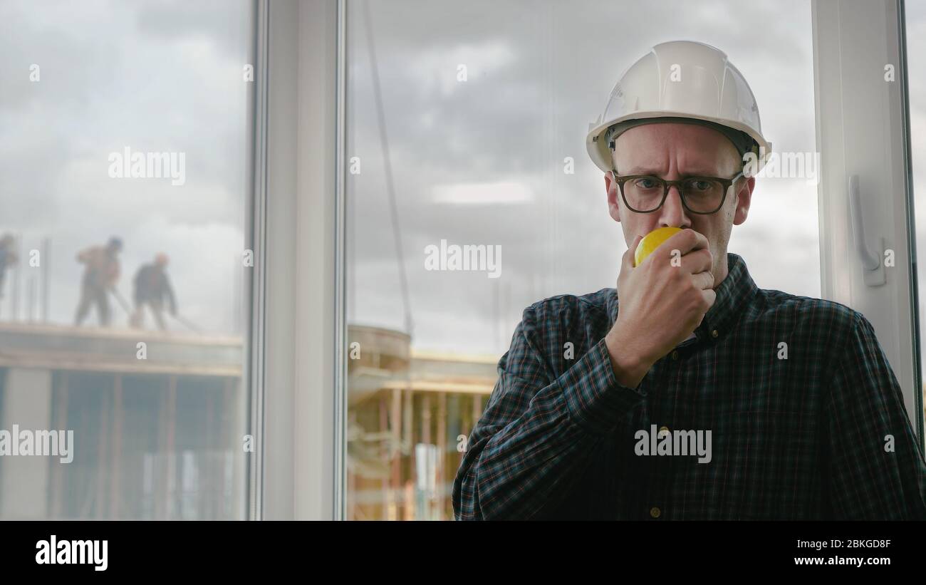 Construction worker eating an apple. Stock Photo