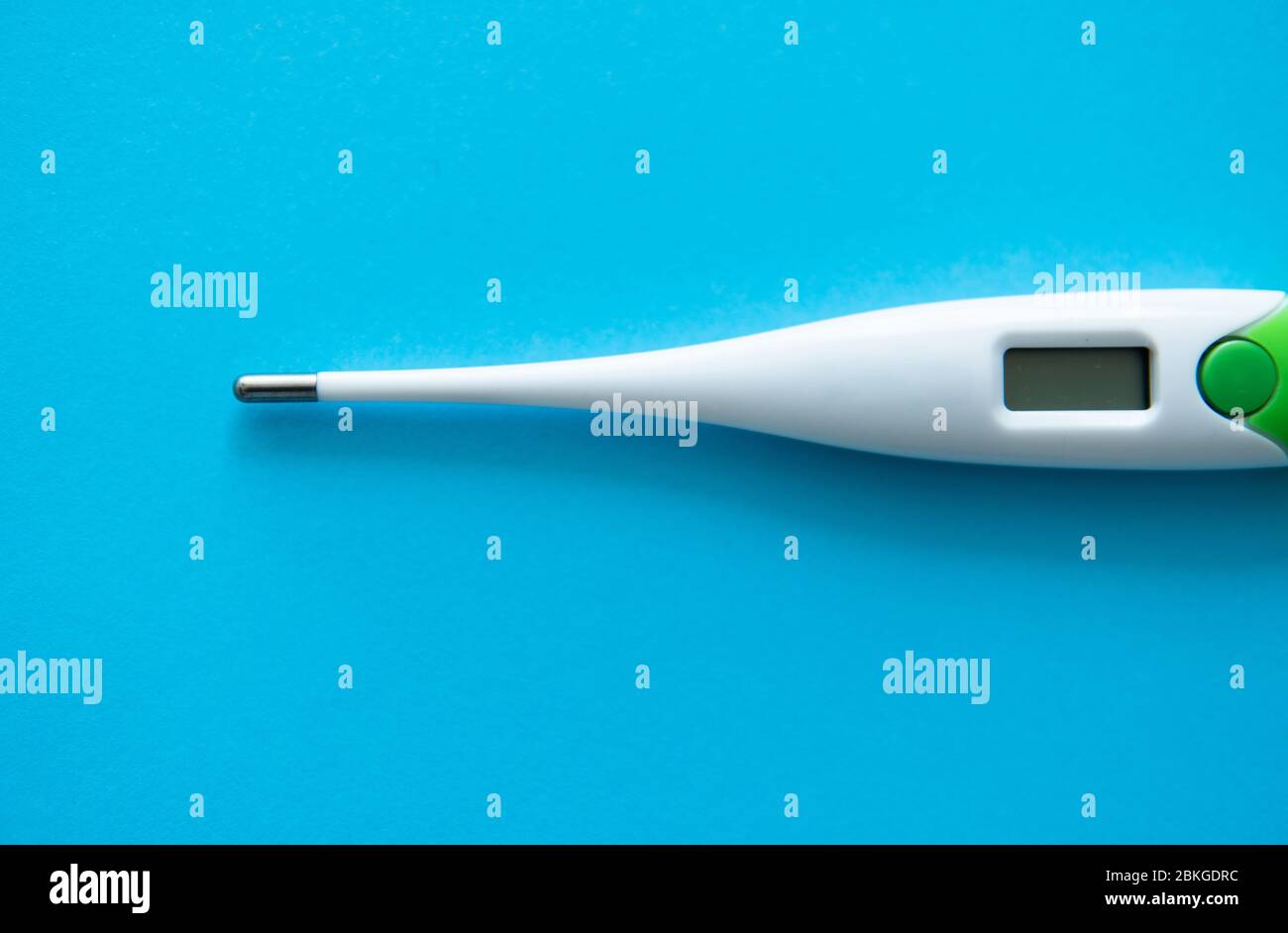 Digital body thermometer lying on a blue background. Medical thermometers. Stock Photo