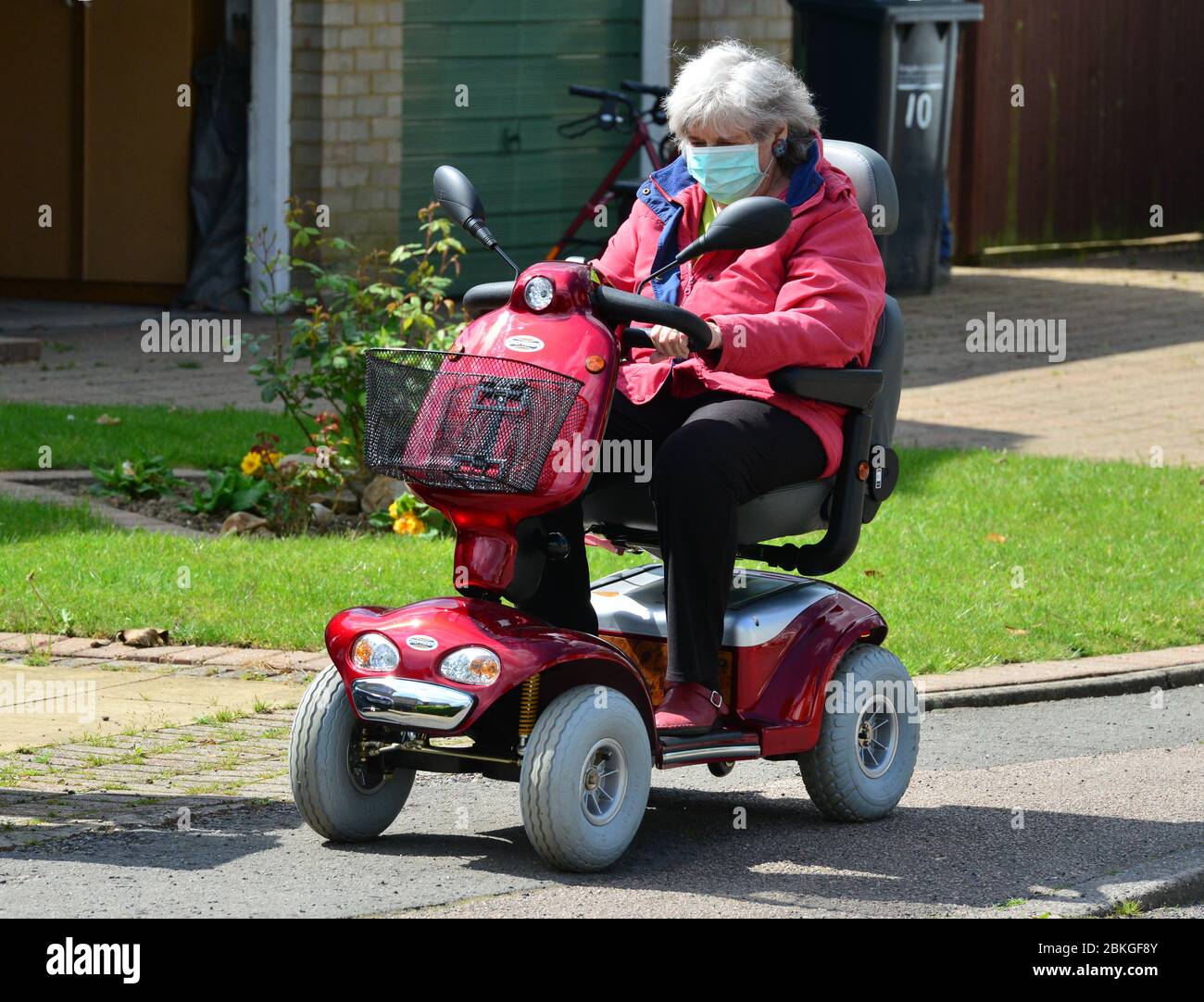 A Lady on a mobility scooter wearing PPE during the Covid-19 Lockdown Stock Photo