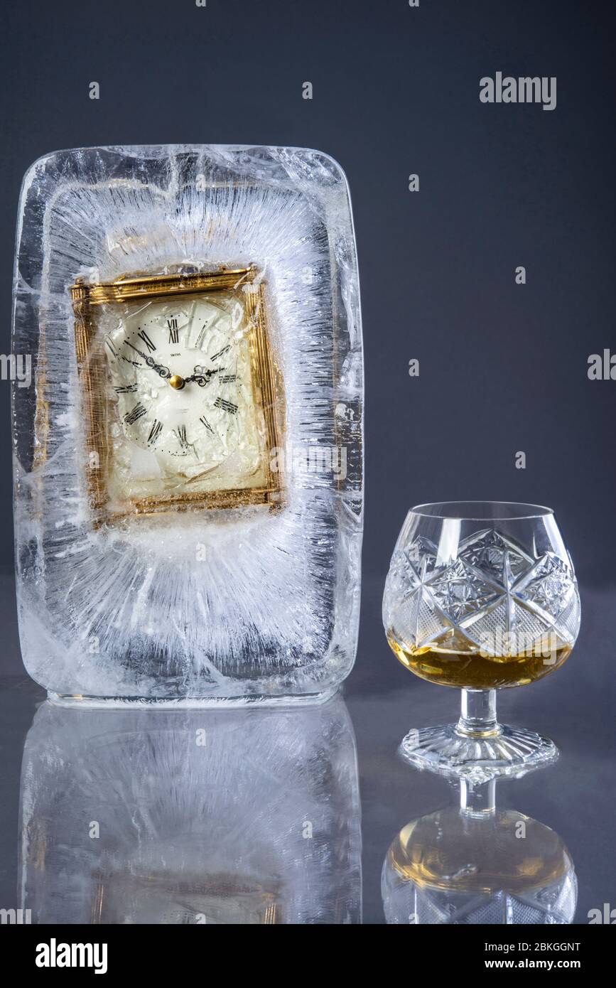an old clock frozen in a lump of ice Stock Photo
