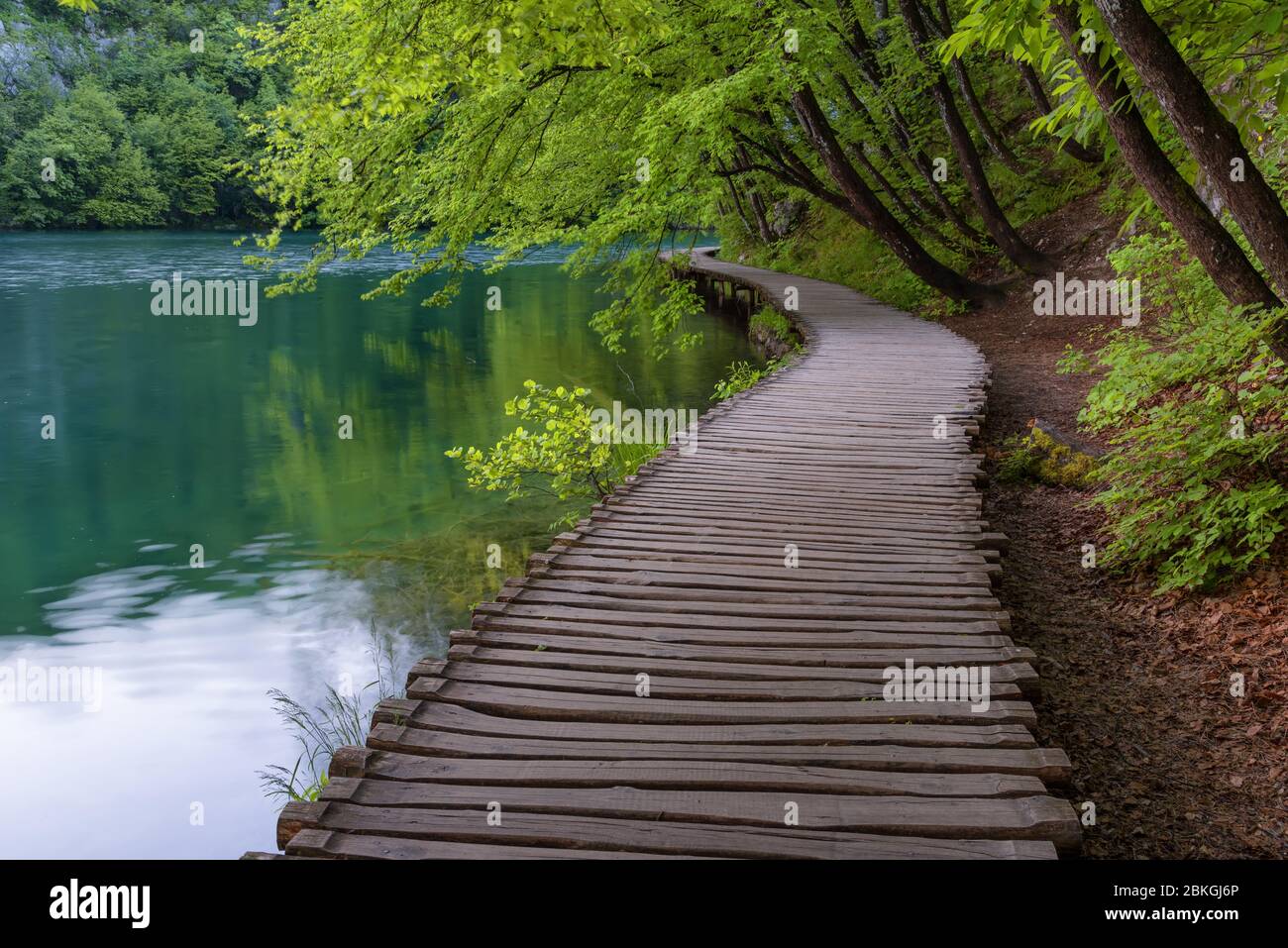 Beautiful view of waterfalls with turquoise water and wooden pathway through over water. Plitvice Lakes National Park, Croatia. Famous attraction Stock Photo